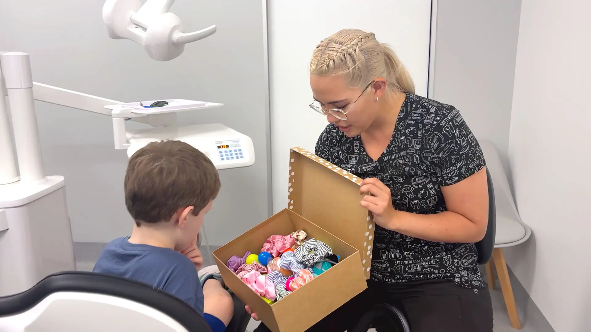 Young boy looking through treasure chest of toys from the dentist.