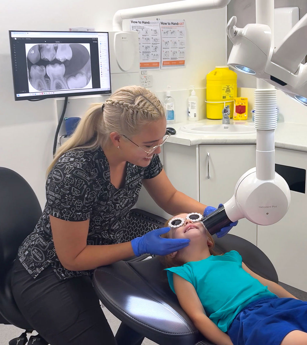 Young girl in dental chair getting an x-ray from the dentist.