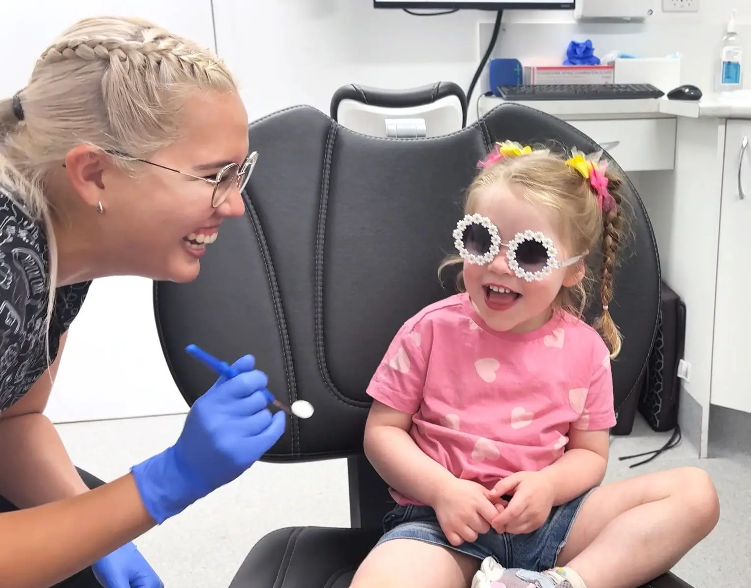 Young happy girl with pigtails wearing flower-shaped protective glasses.